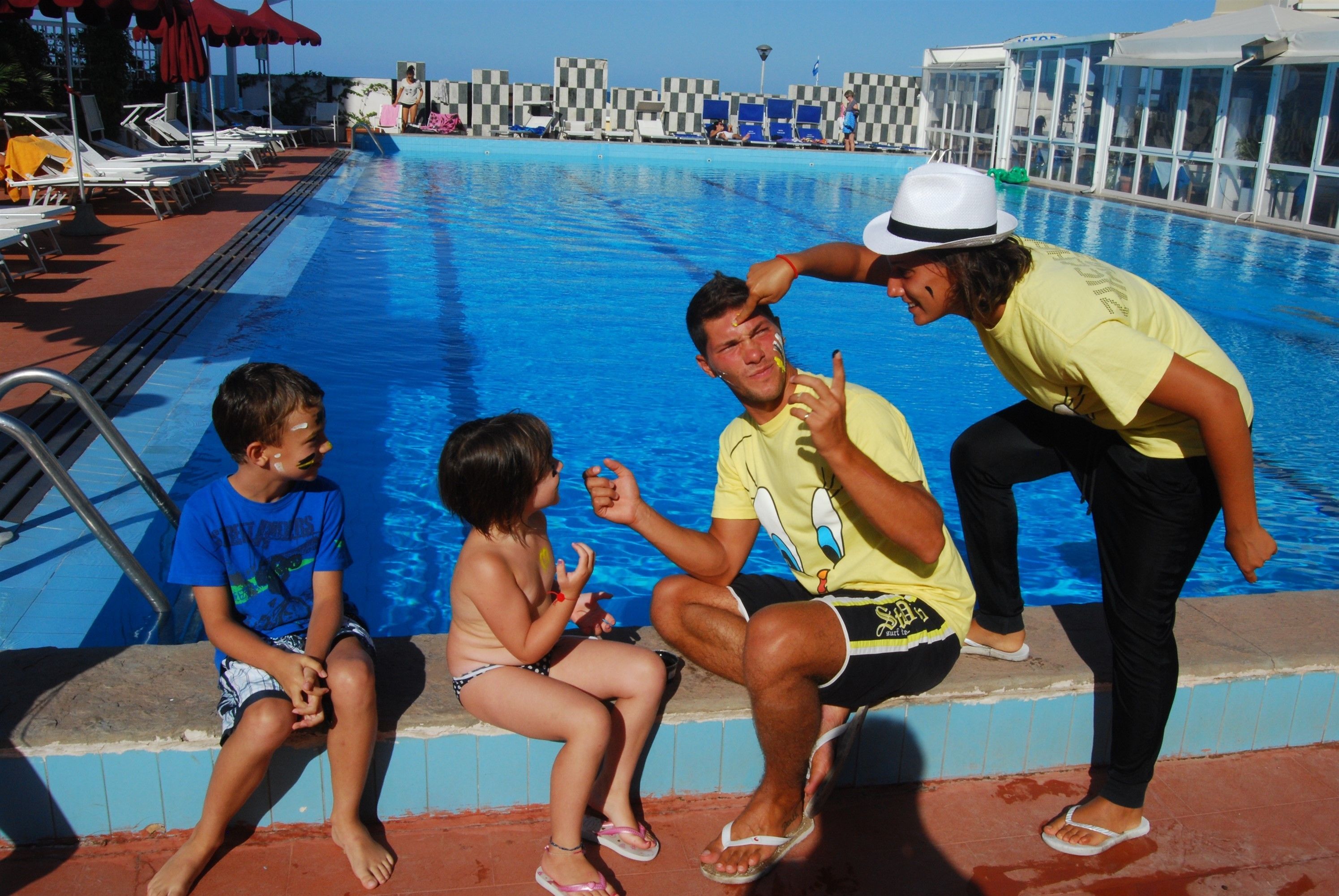 A swimming pool with lounge chairs and umbrellas.