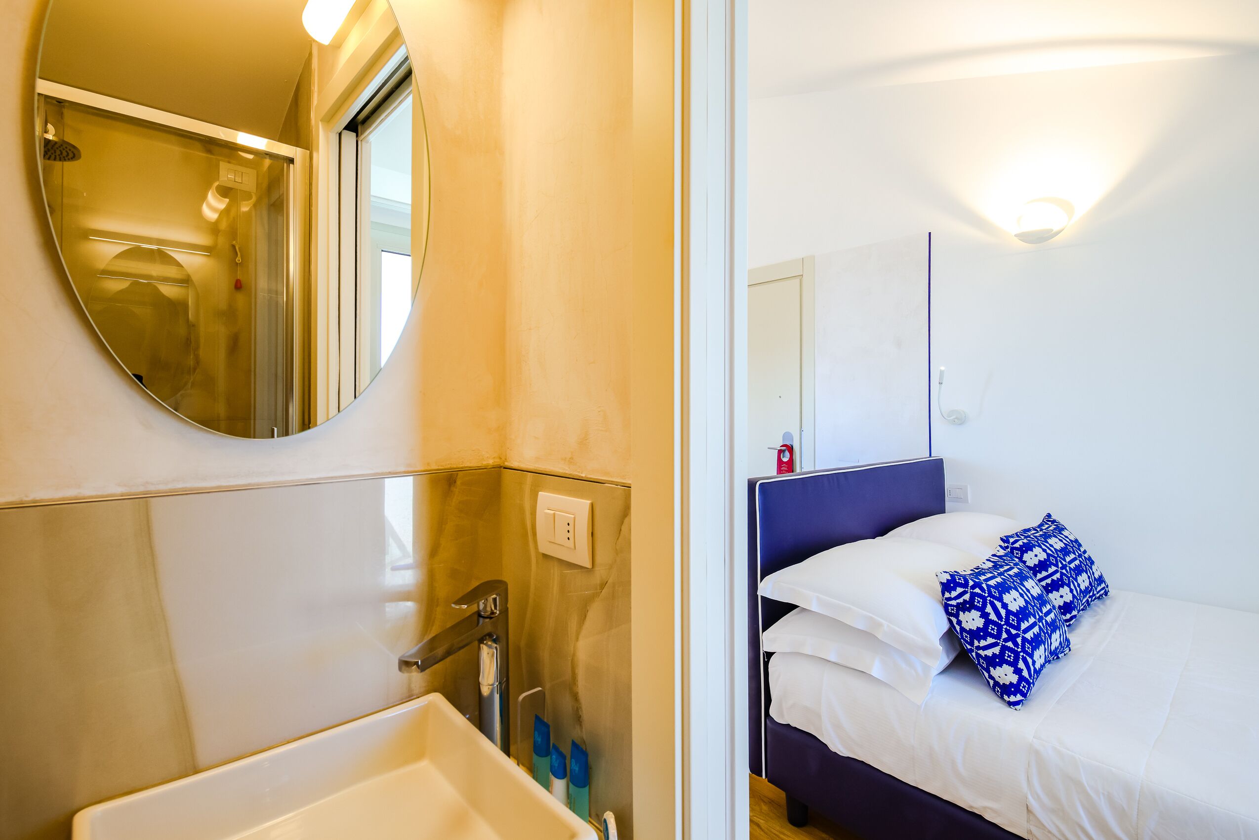 A bathroom with a sink, mirror, and shower.