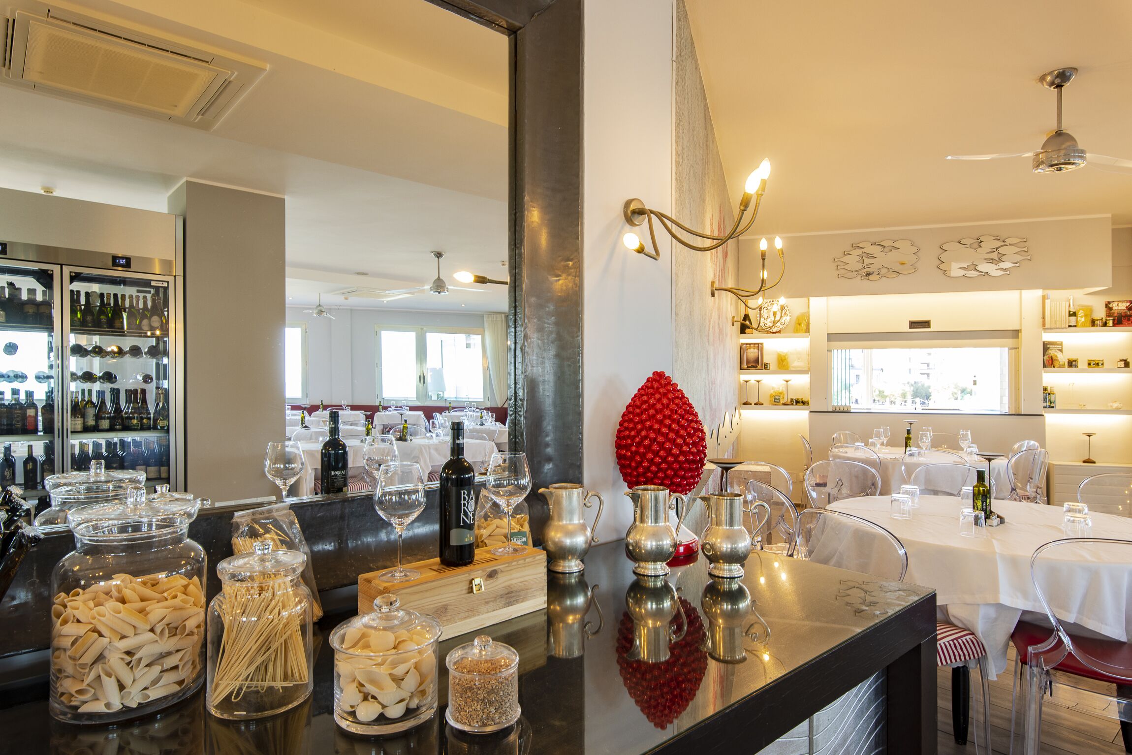 A restaurant interior with a bar area, wine glasses, and a decorative red sphere.