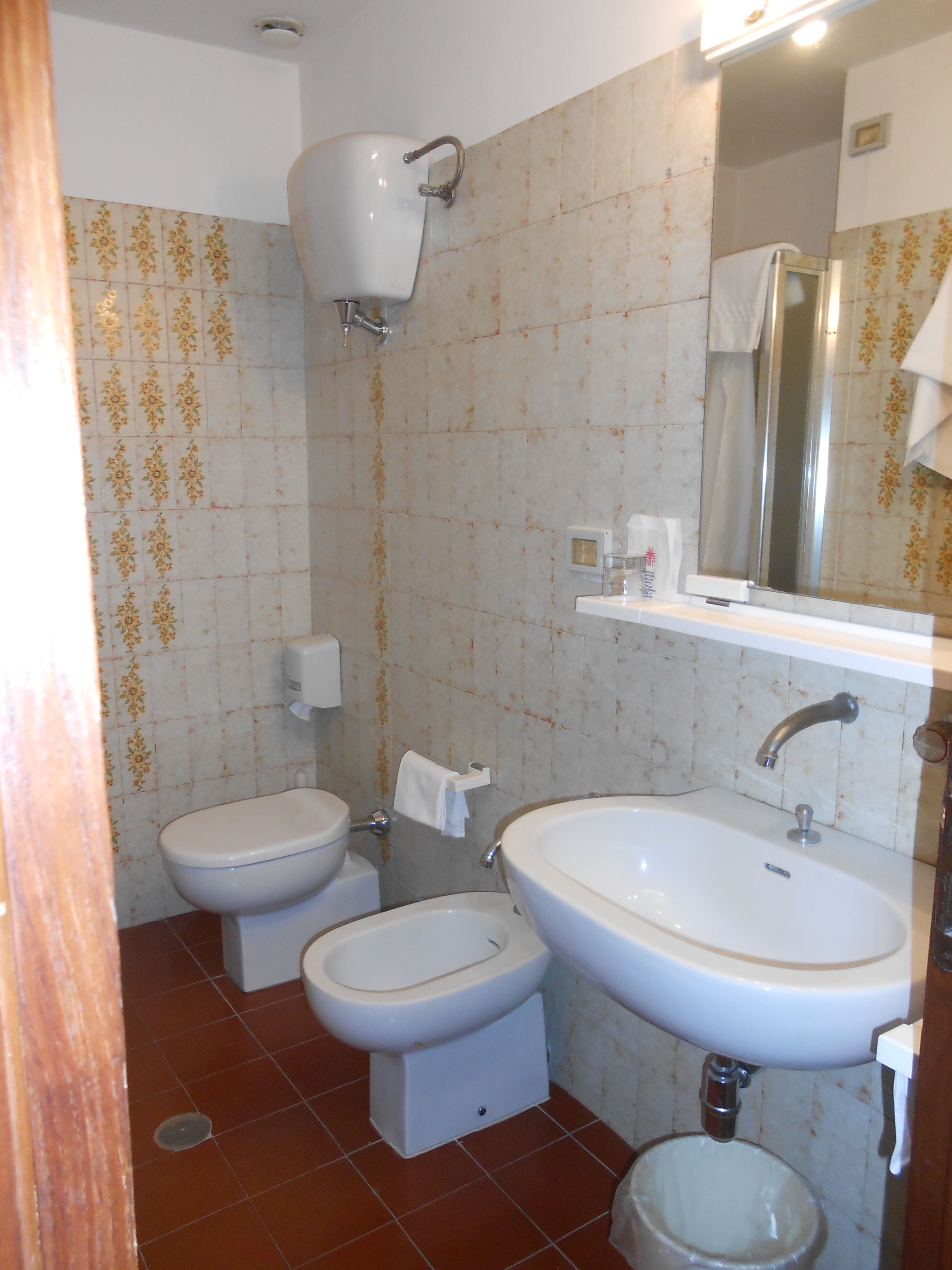 Un baño con inodoro, bidé y lavamanos.