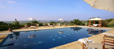 Una piscina al aire libre, tumbonas