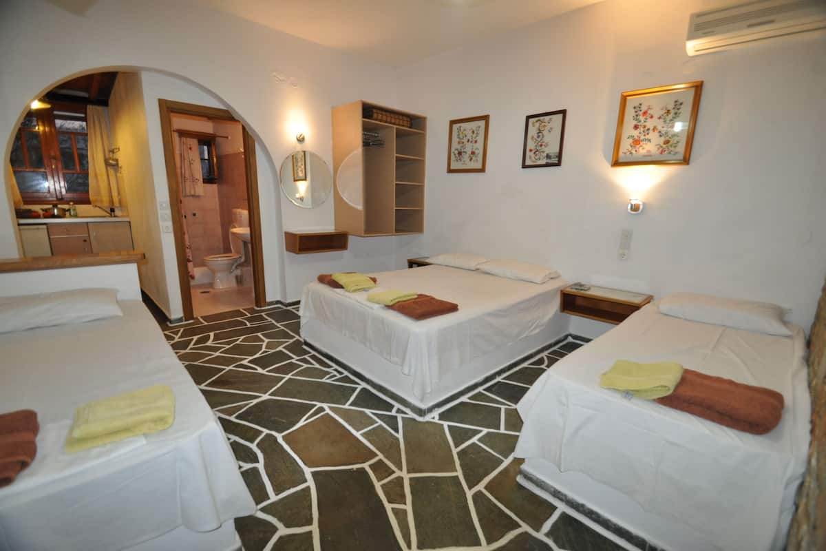 A hotel room with two beds, a bathroom, and a kitchenette.