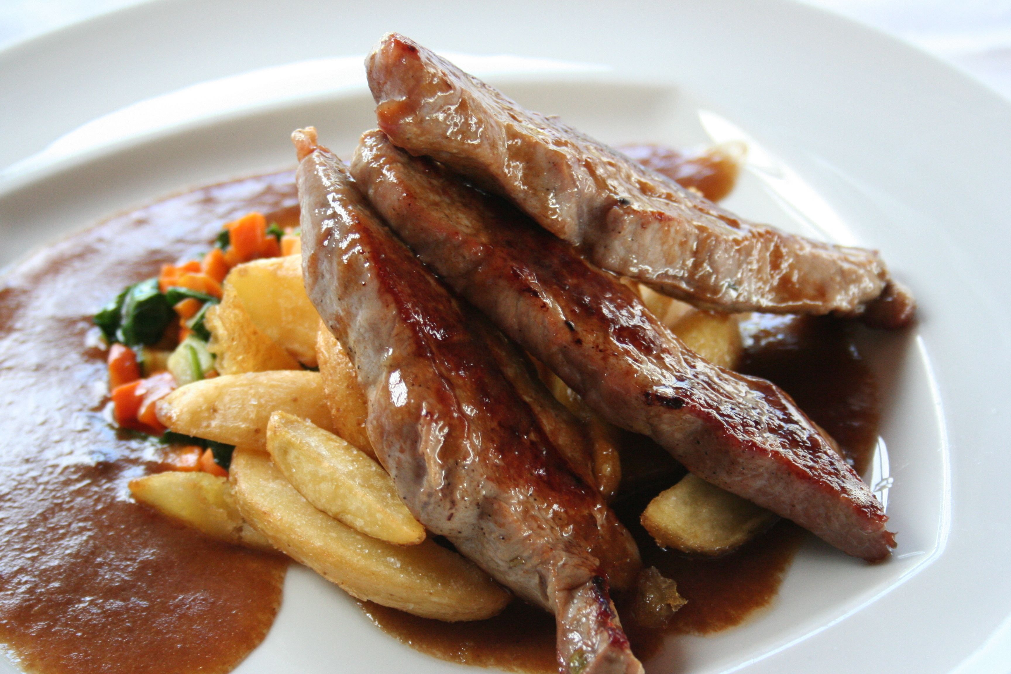 Un piatto con carne, patate e verdure.