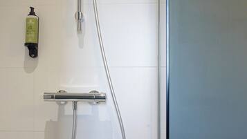 A shower with a handheld showerhead and a wall-mounted faucet.