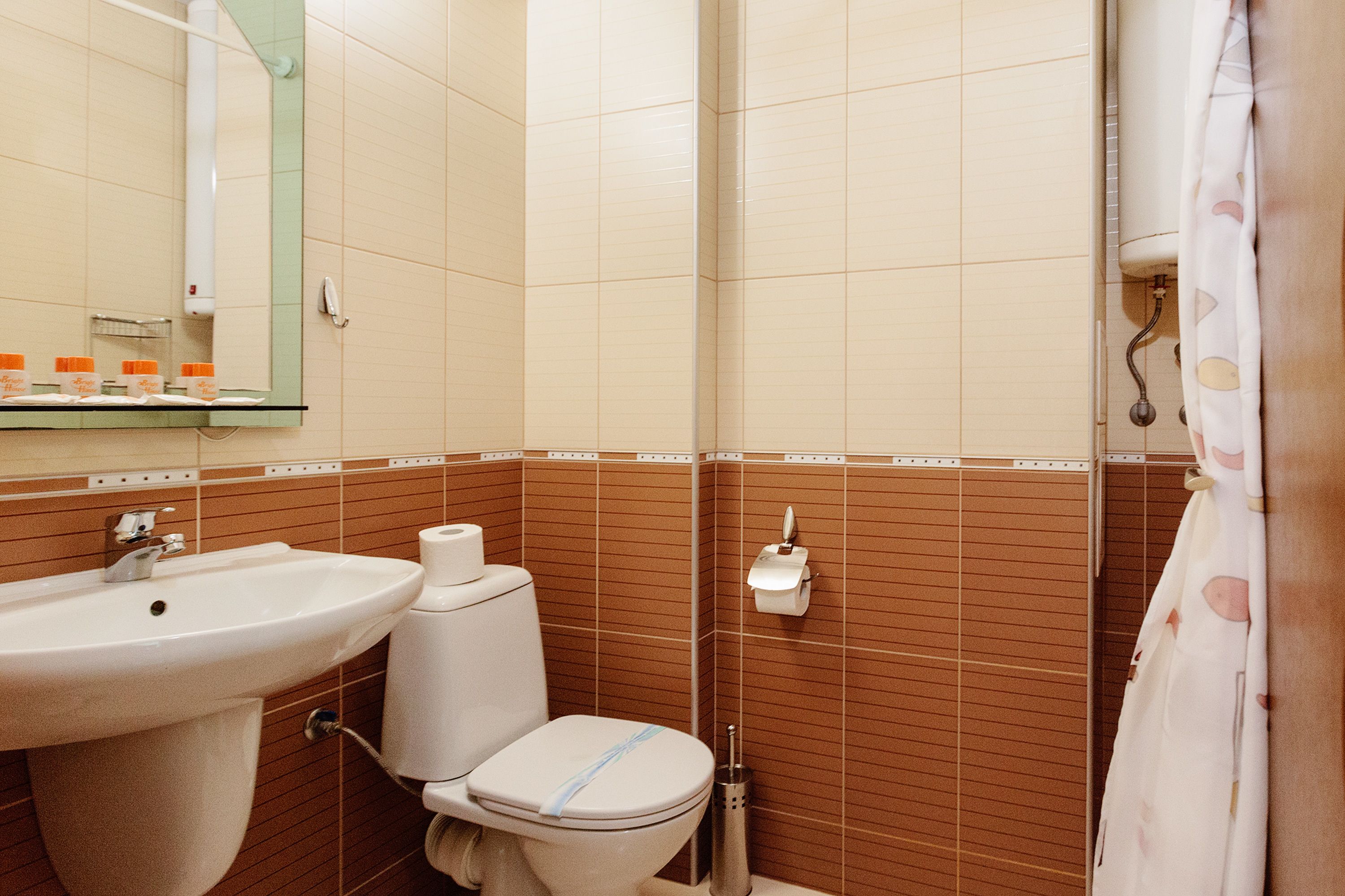 Un baño con lavamanos, inodoro y espejo.