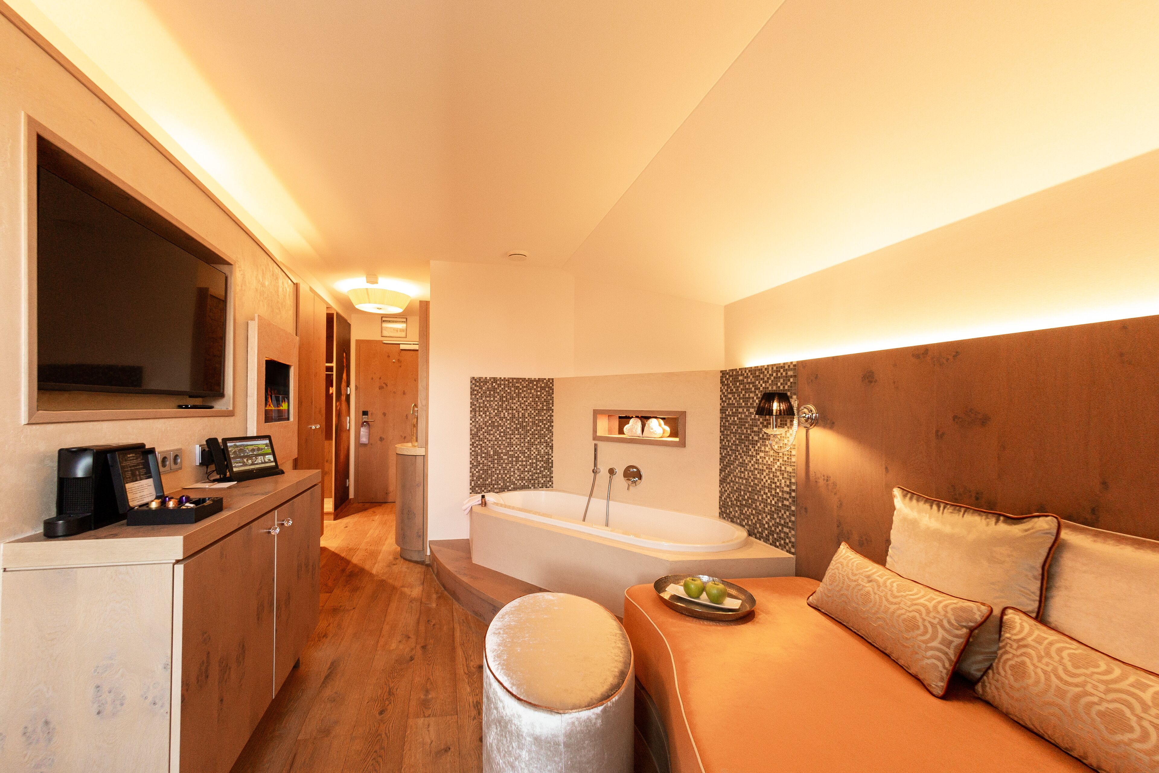 A modern bathroom with a bathtub, a vanity with a mirror, and a toilet.