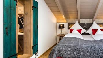 Un dormitorio con una cama, puertas de madera color turquesa, una mesita de noche y una lámpara.
