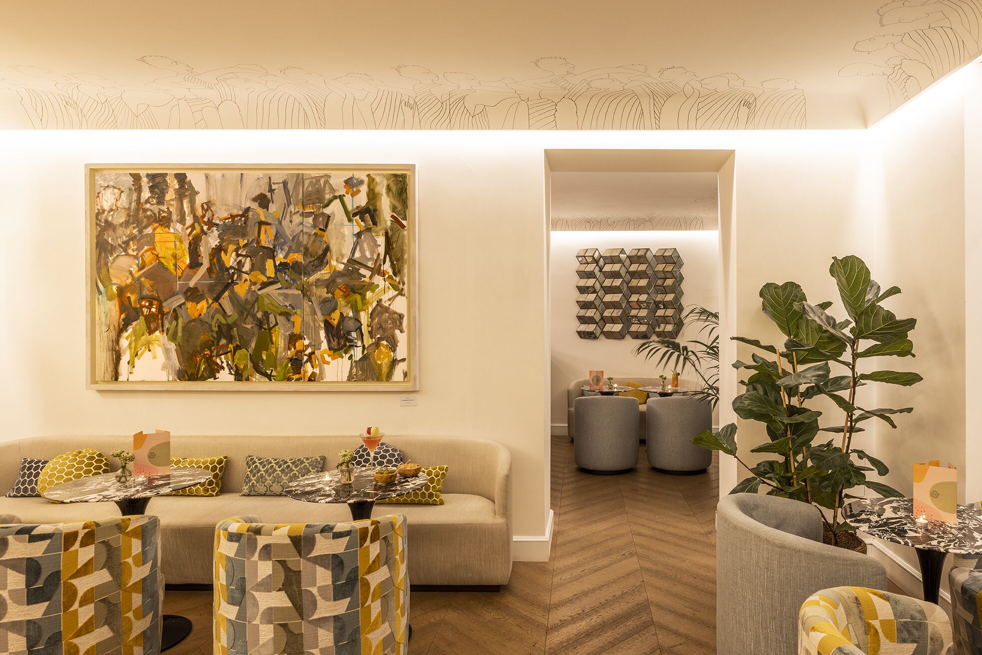 A modern living room with a large abstract painting, a sofa set, patterned chairs, and a dining area with a geometric wall art piece.