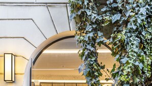 A bar area with a glass enclosure, a bartender, and a selection of bottles. - Nerva Boutique Hotel (Rome)