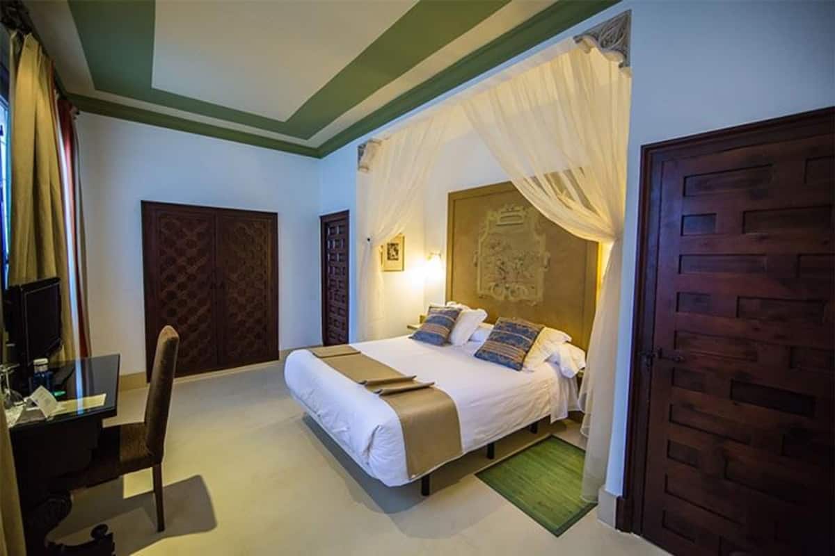 Quarto com uma cama, uma escrivaninha e uma cadeira.