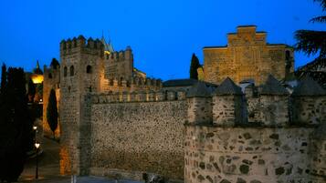 Un castillo de piedra histórico con torres almenadas y un muro fortificado.