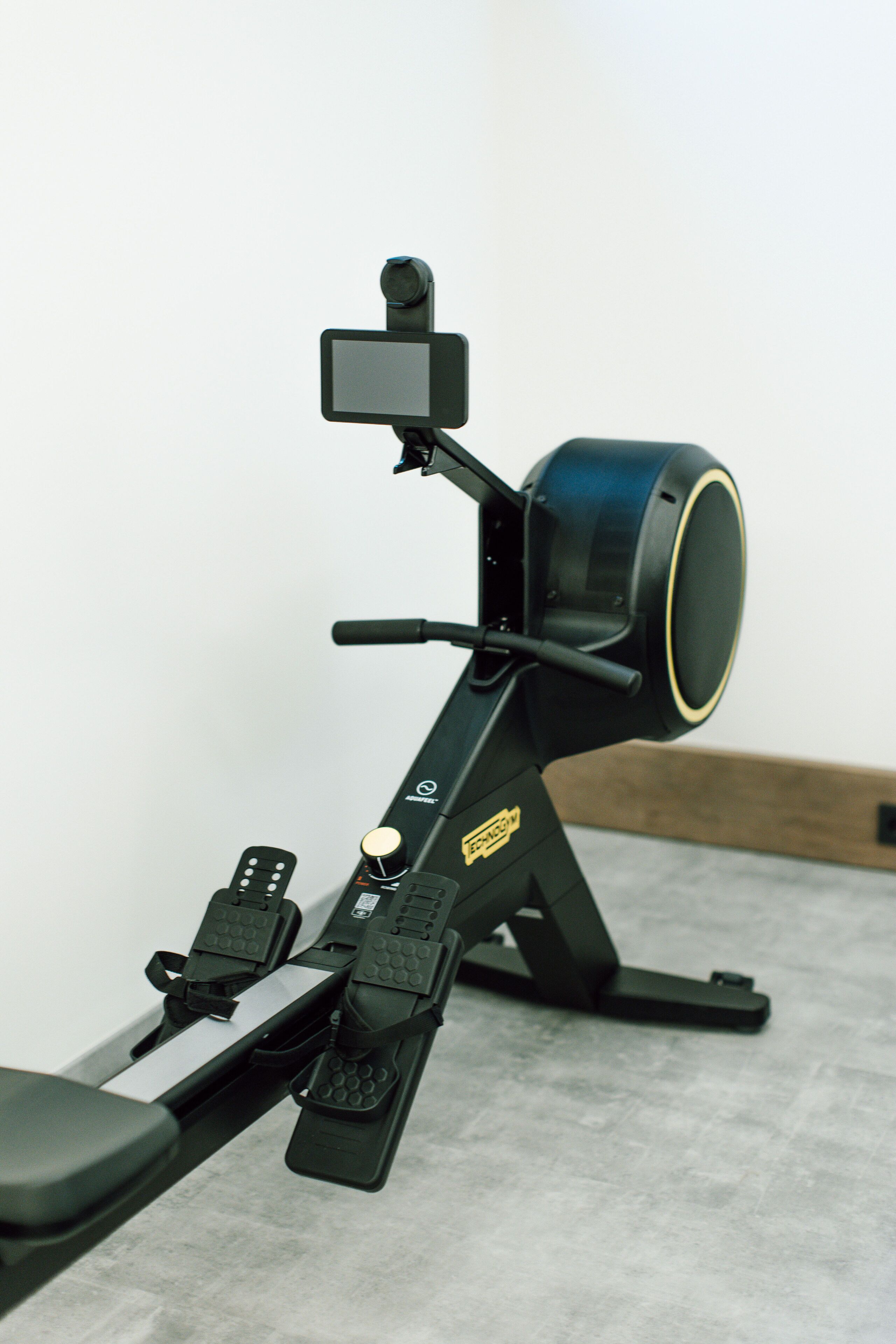 A stationary exercise bike with a digital display, foot pedals, and a handlebar.