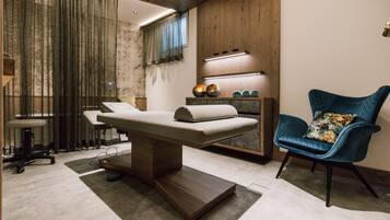 Features a cushioned examination table, a comfortable armchair, and a shelf.