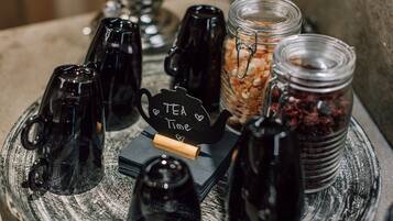 Uma estação de chá com vários recipientes e um letreiro que diz 'Tea Time'.