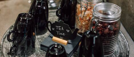 A tea station with various containers and a sign that reads "Tea Time".