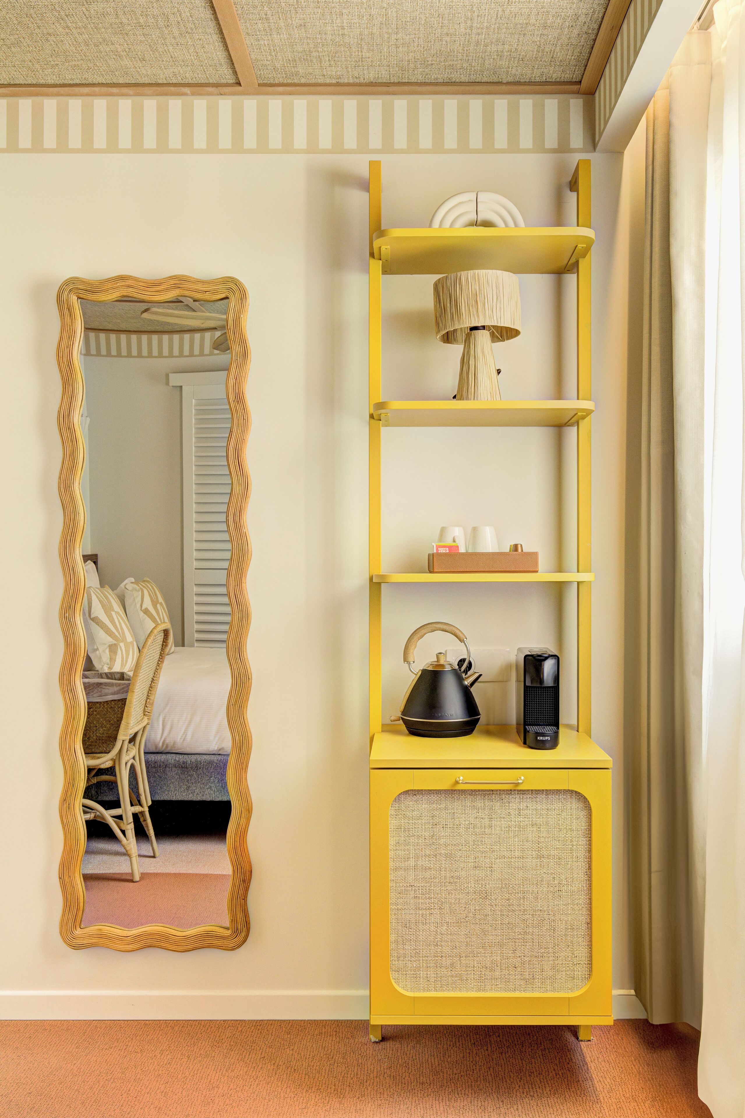 Una habitación con una estantería amarilla, un espejo, una cama y una silla.
