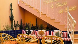Una escalera con un letrero de neón que dice "Cocktails & Campfire de Soleil".