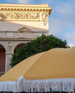 A building facade with ornate carvings and a large archway. - Hôtel Gabriel - Nouveauté 2025 (Menton)