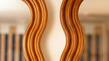 Un miroir en bois à fixer au mur, doté d’un motif ondulé.