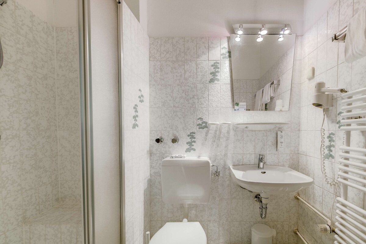 Un baño con inodoro, lavabo y zona de ducha.
