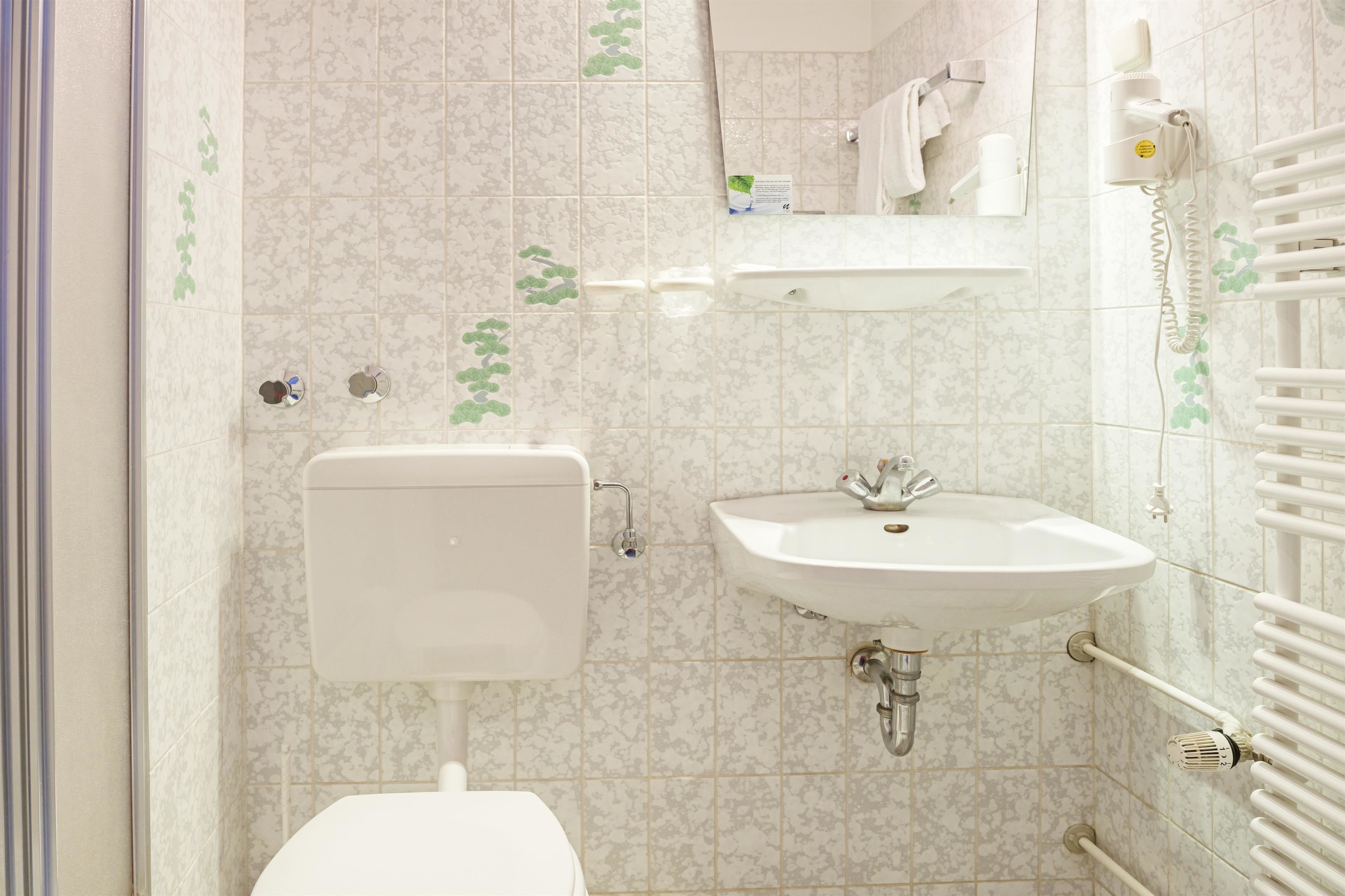 Ein Badezimmer mit Toilette, Waschbecken und Handtuchhalter.