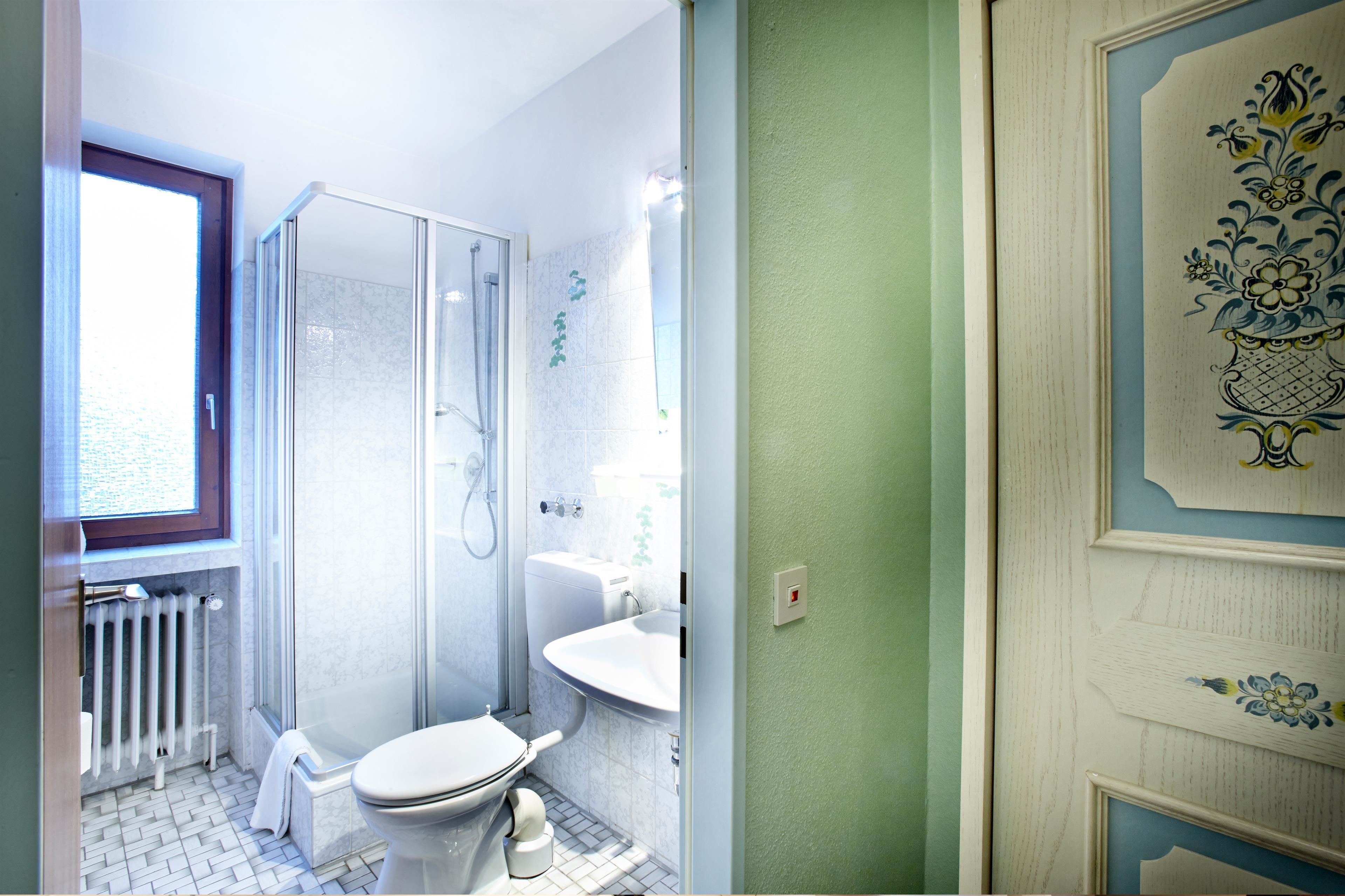 A bathroom with a shower, toilet, and sink.