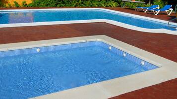 Una piscina al aire libre de temporada, sombrillas
