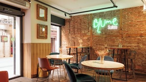 Un interior de restaurante con paredes de ladrillo, mesas redondas y sillas.