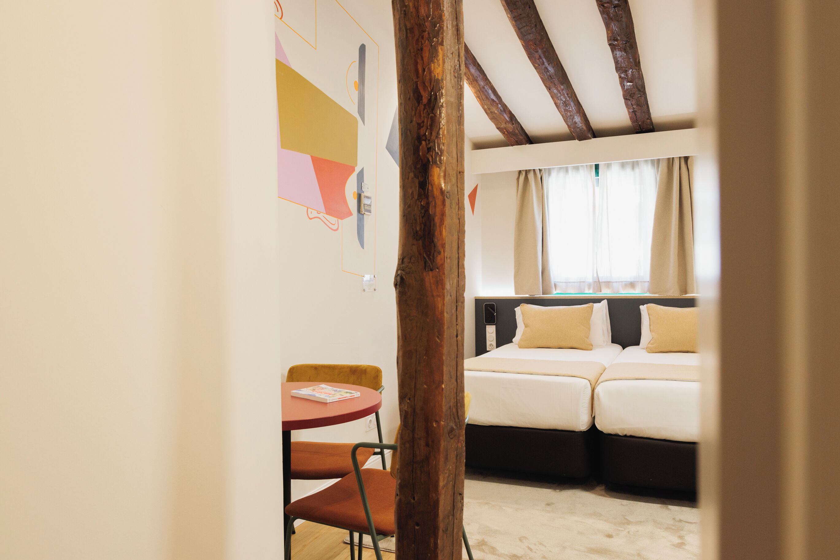 Une pièce avec un lit, une petite table et une chaise.
