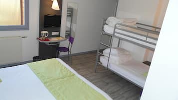 A hotel room with a bunk bed, a desk with a chair, a television, and a window with blinds.