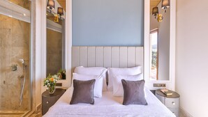 A hotel room with a large bed, a shower, a nightstand, and a view of the outdoors. - Hera Hotel Kas (Kaş)