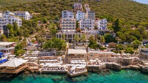 A coastal town with a marina, clear turquoise waters, and buildings with balconies overlooking the sea. - Hera Hotel Kas (Kaş)