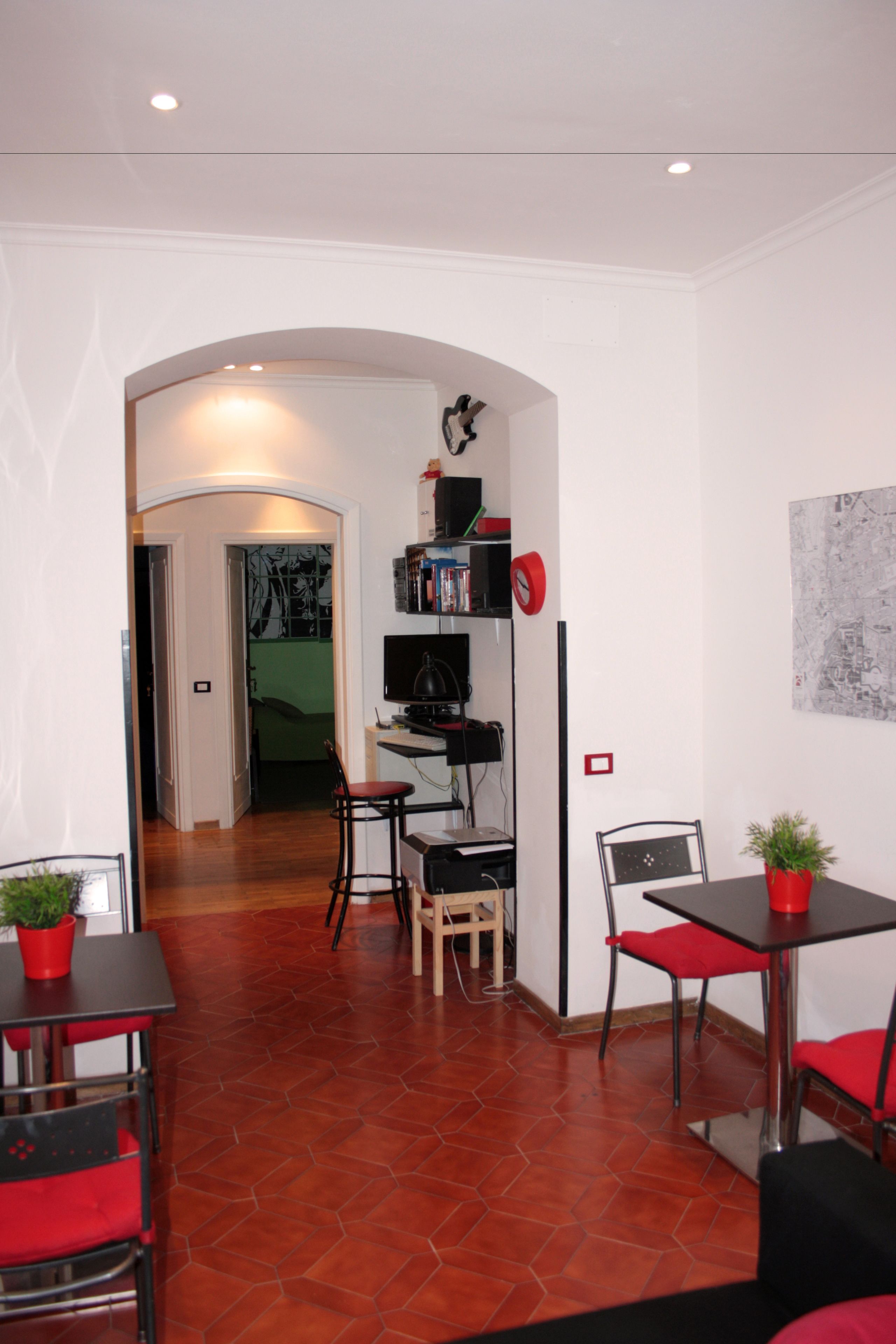 A modern room with a dining area, a small kitchen, and a bookshelf.