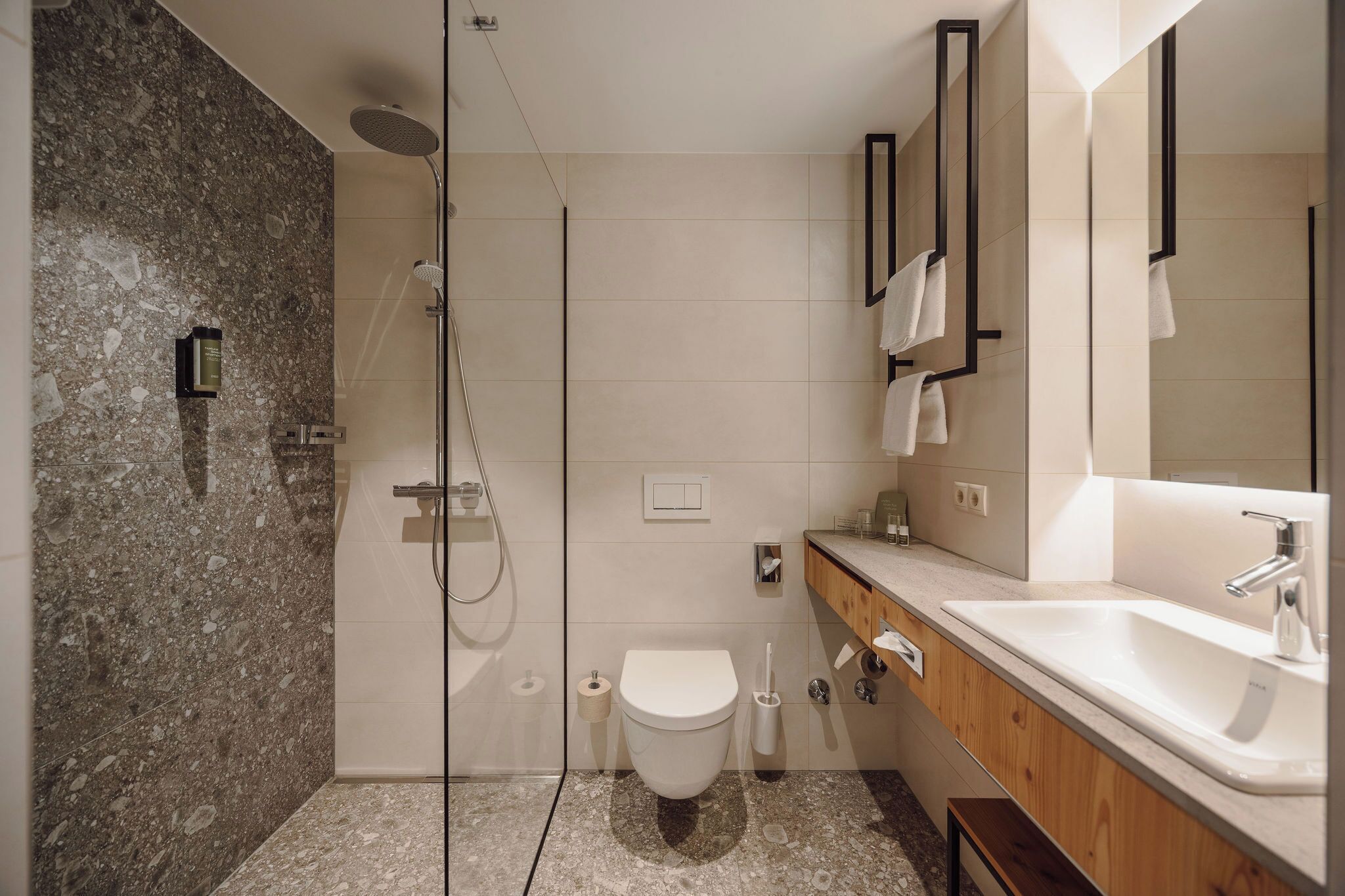 A modern bathroom with a shower, toilet, and sink.