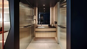 A modern bathroom with a sleek design, featuring a large mirror, a sink, and a towel rack. - Dips&Drops – SUPERIOR HOTEL · SPORTS · SPA · RESTAURANTS (Flachau)