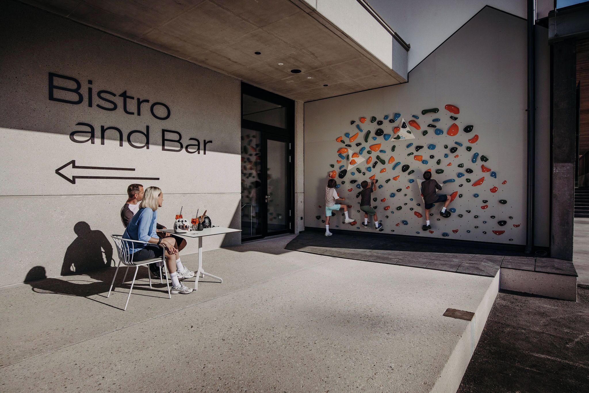 A modern bistro and bar with a climbing wall feature.