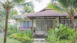 A house with a porch, surrounded by lush greenery and palm trees. - Centara Chaan Talay Resort & Villas (Trat)