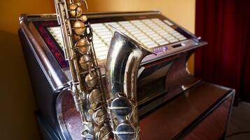 Een saxofoon op een houten oppervlak met een muntgleuf, vermoedelijk onderdeel van een jukebox.