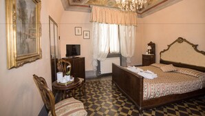 A bedroom with a checkered floor, a large bed, a chandelier, and a mirror. - Relais Centro Storico Pisa (Pisa)