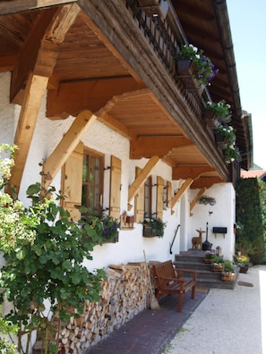 A traditional chalet with a wooden balcony, wooden beams, and flower boxes.