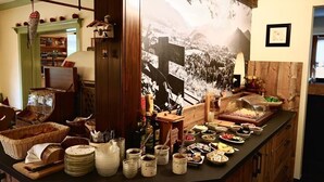A buffet setup with various food items and condiments. - Hotel Garni Landhaus Traunbachhäusl (Ruhpolding)