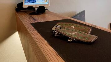 Un mostrador de recepción de madera con un monitor de computadora que muestra un escritorio con varias ventanas. Sobre el mostrador, una billetera de cuero con un llavero.