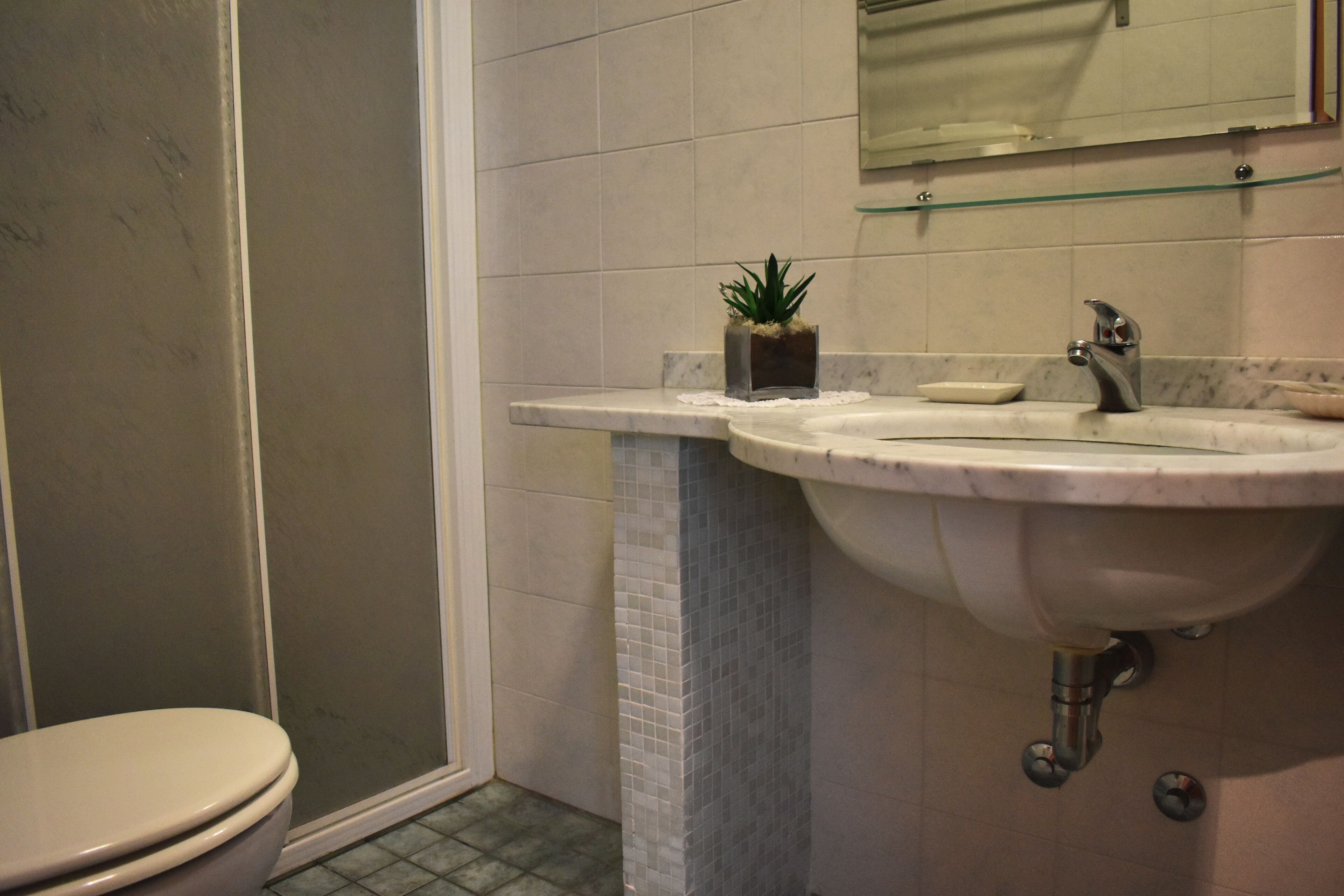 Une salle de bain avec des toilettes, un lavabo et une douche.