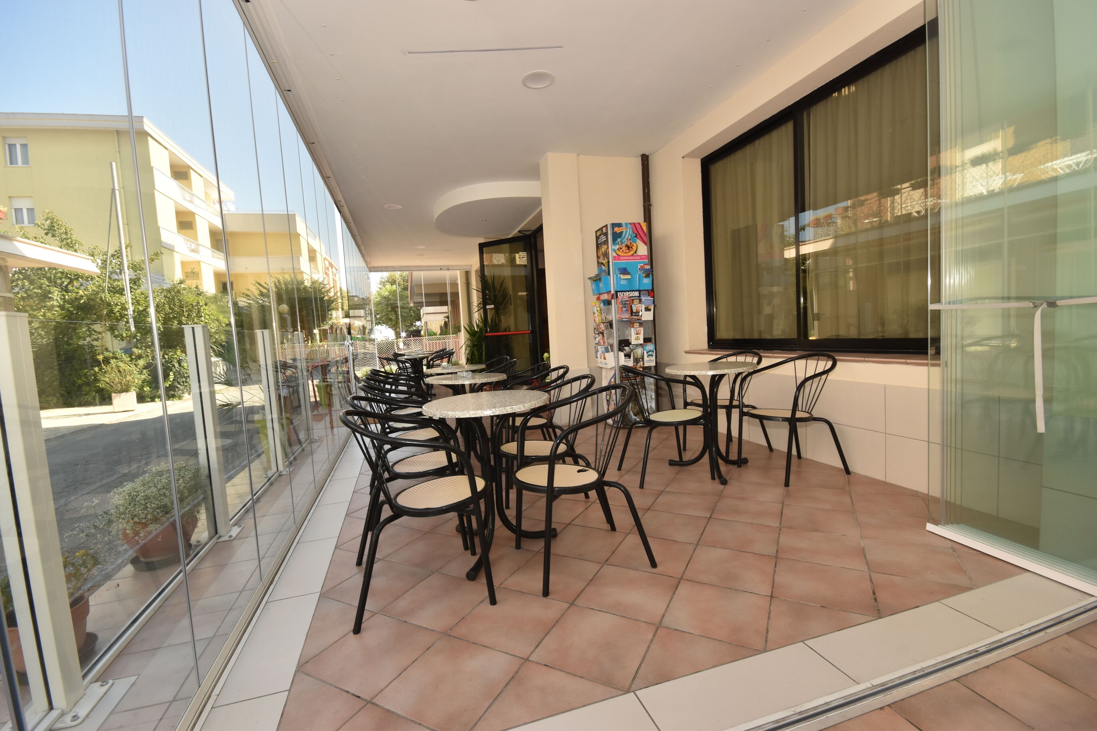 A balcony with outdoor seating, a glass wall, and a view of the street.