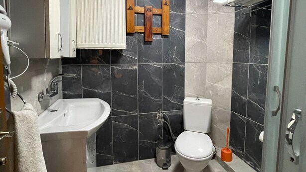 A bathroom with a sink, toilet, and shower area. - Lale Pansiyon (Egirdir)