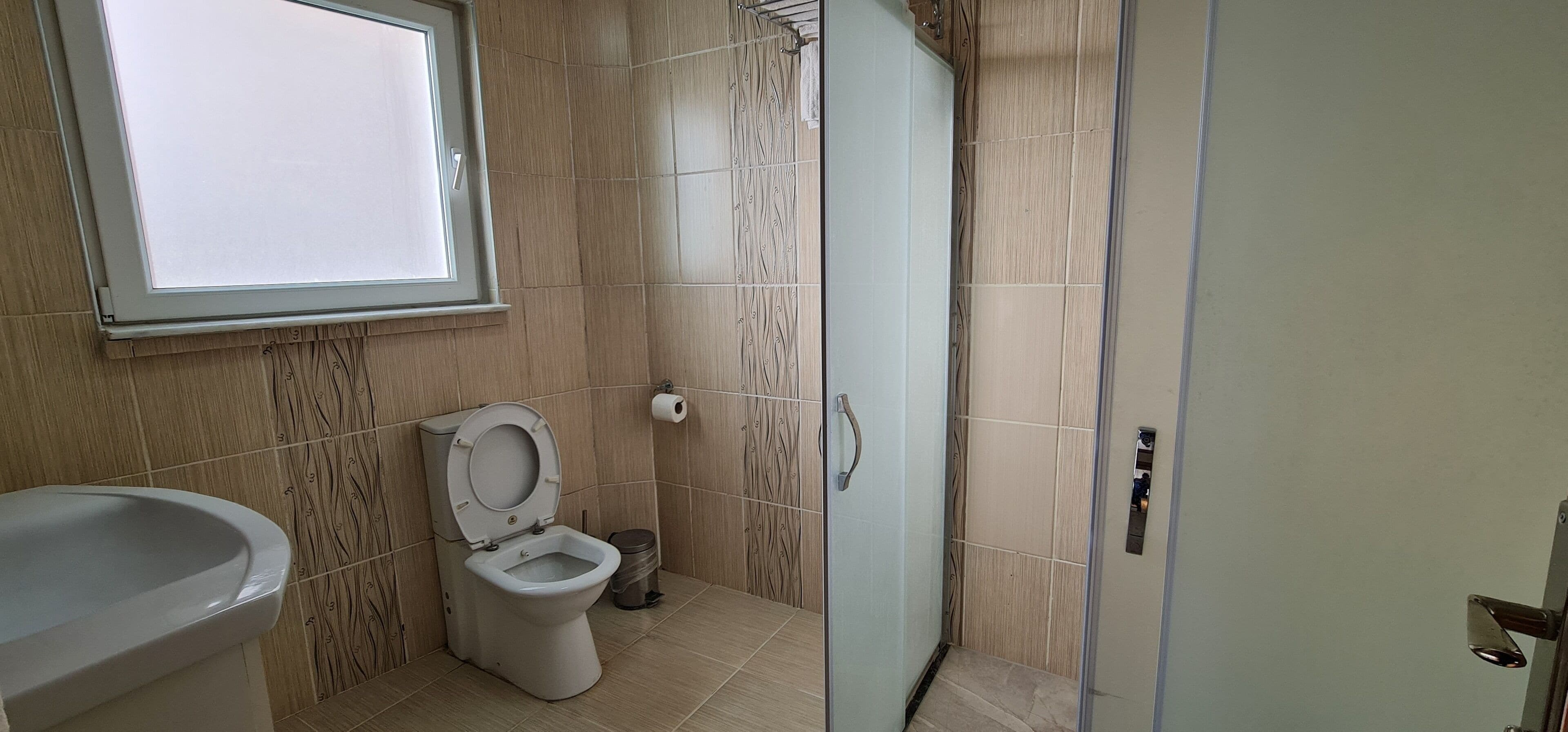 Un bagno con il water, un lavandino e una zona doccia.