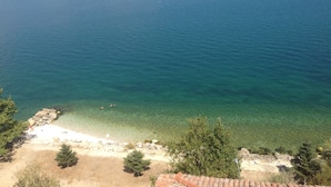 A coastal view with clear water, a sandy beach, and rocky outcrops. - Lale Pansiyon (Egirdir)