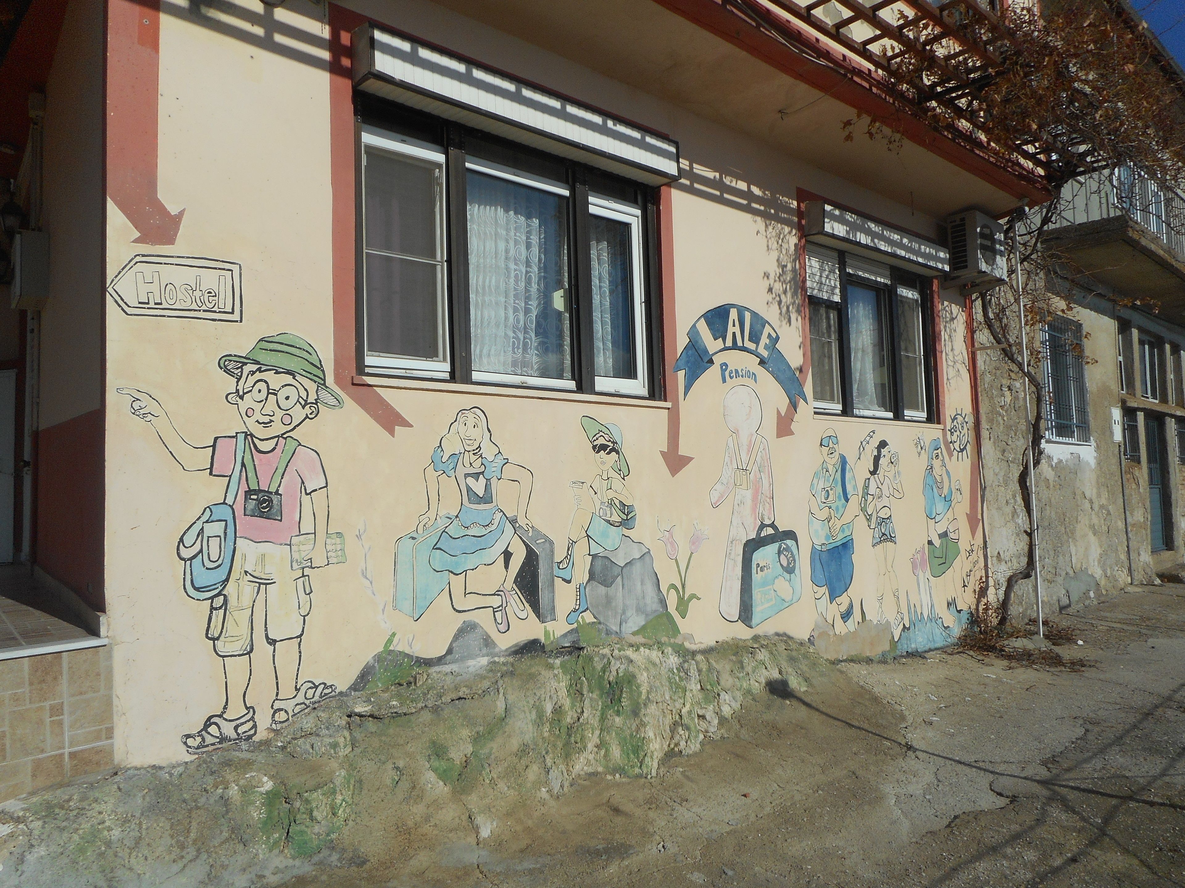 A hostel with a mural depicting various characters and activities.