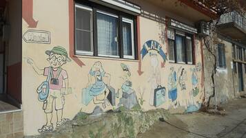 A hostel with a mural depicting various characters and activities.