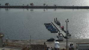 A waterfront view with boats docked, a pier, and mountains in the background. - Lale Pansiyon (Egirdir)